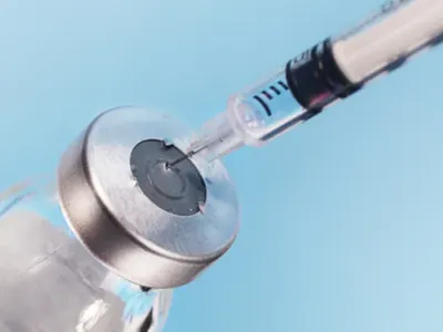 Syringe drawing liquid from a vial