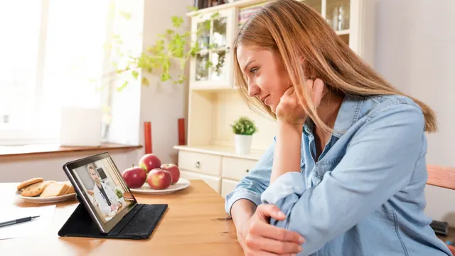 Woman meeting a provider by video on a tablet at home